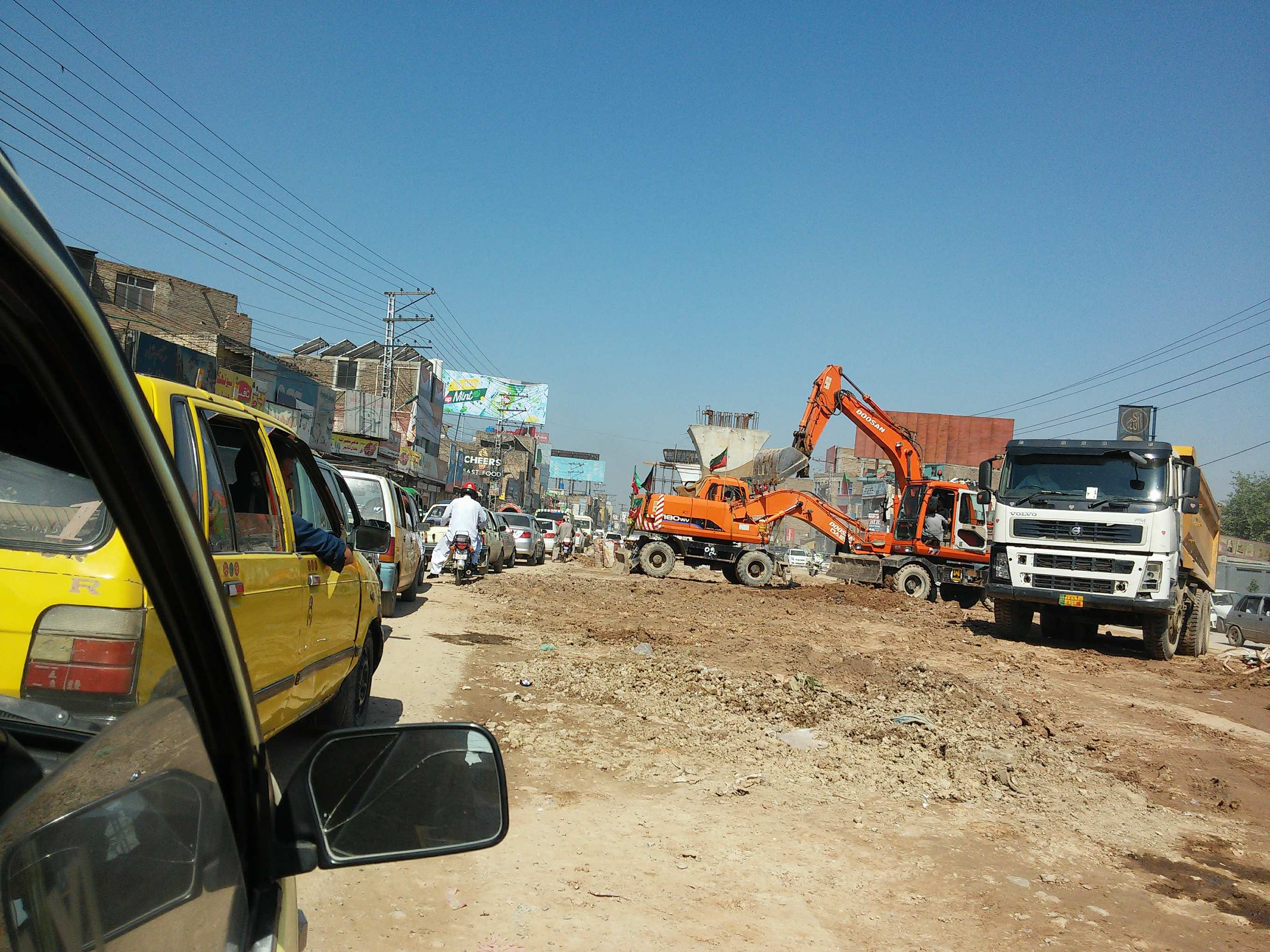 Cars in stand still traffic with nothing to seperate them from the construction site of BRT less than a meter away 