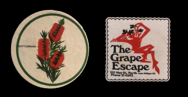 Two postcards from the 1970s. One has a drawing of an Australian bottlebrush. The other says "The Great Escape" and has a drawing of a red outline of a man eating grapes like a roman sitting on a chaise.