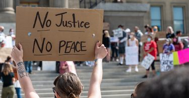 BLM protest sign saying no justice no peace